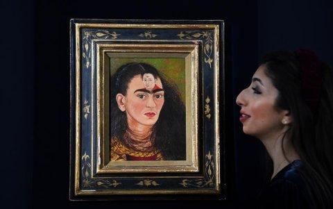 El personal de una casa de subastas de Sotheby's con el último autorretrato del 'busto' de la artista mexicana Frida Kahlo, titulado 'Diego y yo' (Diego y yo), en Sotheby's en Londres, Gran Bretaña, el 21 de octubre de 2021.