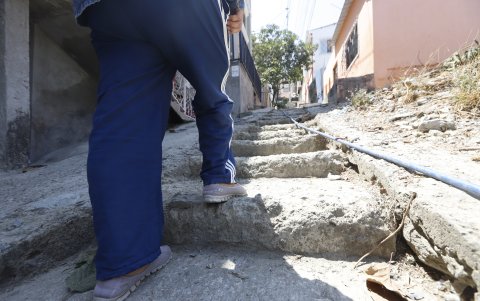 Las tuberías de aguas servidas y las mangueras por donde se abastecen del líquido vital están a la intemperie, producto del desgaste del pavimento. Los residentes deben caminar sobre estos terrenos.