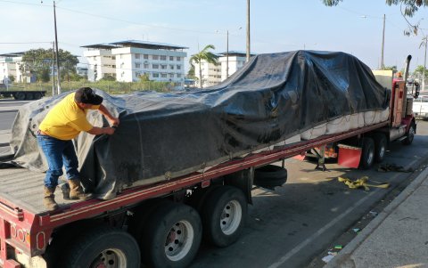 William Garcés coloca plástico sobre la carga que se movilizará. La idea es asegurar que esta no se dañe ante una posible lluvia que los pueda sorprender en el camino.