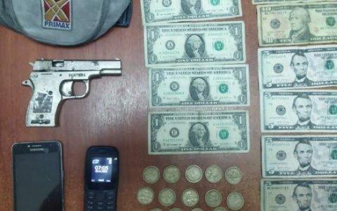 Arma, dinero en efectivo y un bolso de la gasolinera asaltada mostró la Policía como evidencia.