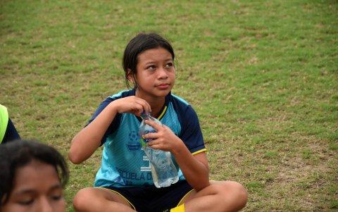 La futbolista escucha con atención las indicaciones del entrenador.