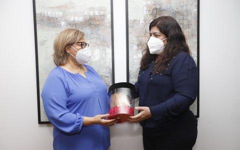 Donación. Yadira Martínez (izquierda), en Guayaquil, hace una entrega simbólica a Elker Mendoza (derecha), familiar de Vicky, a quien donaron las alcancías este año.