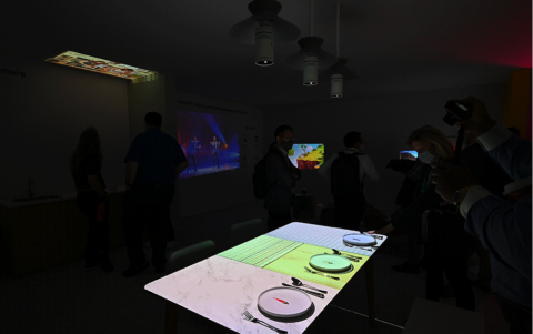 The Freestyle cuelga sobre una mesa de comedor y proyecta animaciones divertidas en las que pequeños personajes se apresuran a entregar comidas 2D en platos 3D.