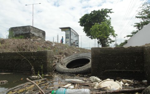 Llantas y todo tipo de basura se encuentra en la zanja al pie de un paradero de bus