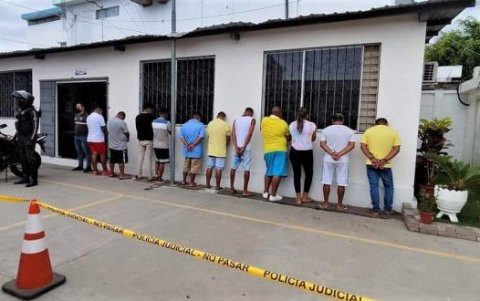 vOnce de los trece detenidos, puestos contra una pared del cuartel policial.