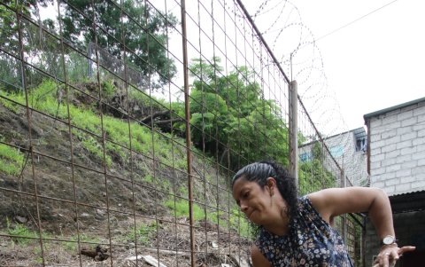 Jéssica Santana sostiene con un palo la malla de fierro colocada para evitar que las rocas caigan al patio de su casa. Pero este objetivo no se ha cumplido.