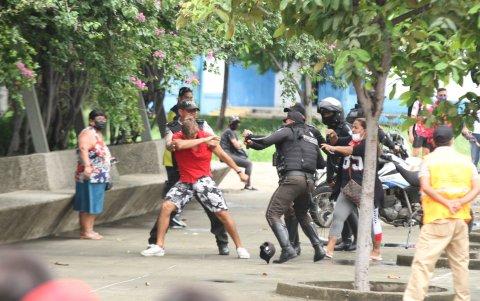 Personal de  la policía controla a un individuo durante la venta de entradas para ver el partido entre Ecuador y Argentina.