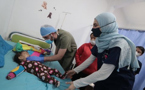 Médicos de la Fundación Global Smile auscultan a la hija de Noelí Vásquez (de rojo), recién operada de labio leporino.