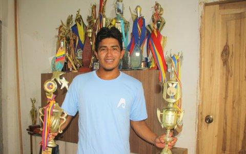 Álex Suárez con sus recuerdos y trofeos por el surf en un rincón de su hogar.