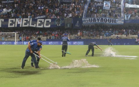 Personal del estadio Capwell intenta desalojar el agua del campo de juego.