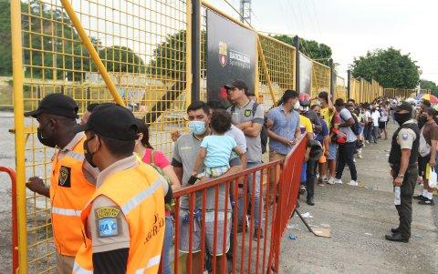 Los aficionados hacen la cola para comprar la entrada en el estadio Monumental, con la supervisión policial.