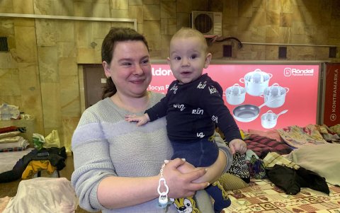 Una mujer y su hijo sonríen a la cámara en el interior de la estación de metro 'Héroes de Dnipra', este lunes en Kiev (Ucrania).