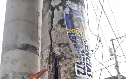 Wellington Lino señala las grietas que tiene un poste cerca de la casa donde vive, en la principal de Vergeles.