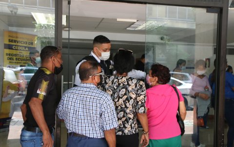 Ciudadanos consultan a un guardia sobre varios trámites, en la matriz del Registro Civil, en el centro de Guayaquil.