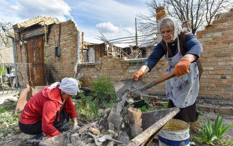 Kiev. Dos mujeres de Zahaltsi, un municipio cercano a la capital de Ucrania, recogen parte de  los restos de lo fue su casa.