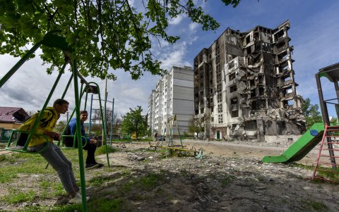 Borodyanka. Un par de muchacho aprovecha lo que queda de un parque comunitario en los alrededores de un complejo de edificios, afectado por el ataque ruso, en este municipio cercano a Kiev.