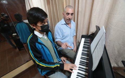 Contacto. Diego Adamus, profesor de piano, con el alumno Diego Jaramillo, en una clase sobre los movimientos que se deben realizar con los dedos sobre el teclado.