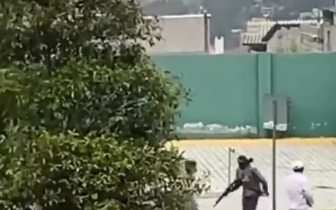 Manifestante. Un encapuchado corre con un arma de fuego en el sector de la Mitad del Mundo.