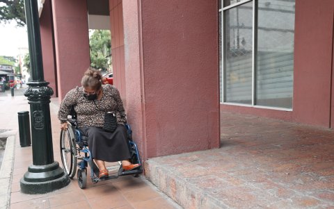 María Elena Rodríguez circula por una vereda en medio de postes y otros elementos que achican el espacio y dificultan su desplazamiento.