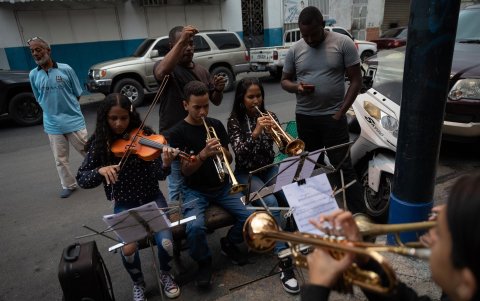 Todo se silencia cuando 18 niños y adolescentes de un humilde barrio de la capital venezolana tocan en plena calle.