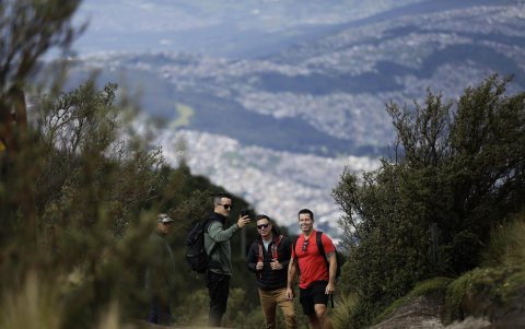 Un grupo de turistas fue registrado este sábado al tomarse una foto, con la ciudad de Quito al fondo y al visitar el teleférico, en la capital ecuatoriana.