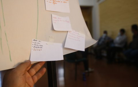 Materiales. Los asistentes usan pedazos de cartulina para escribir y reflejar parte de sus emociones durante la terapia aplicada al grupo.