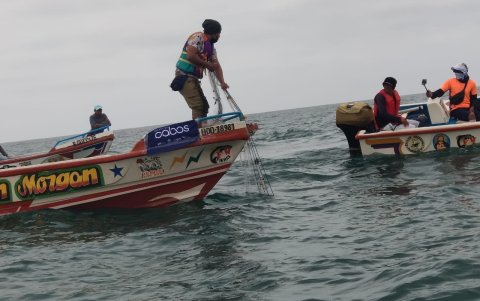 Los pescadores en el instante que retiraban la basura.