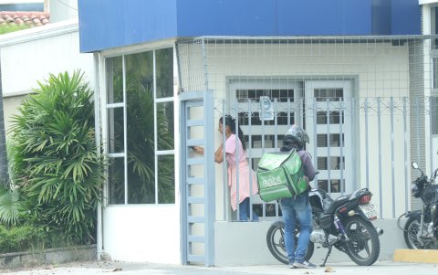 Persona que permanece en edificio sale a retirar una orden de comida.