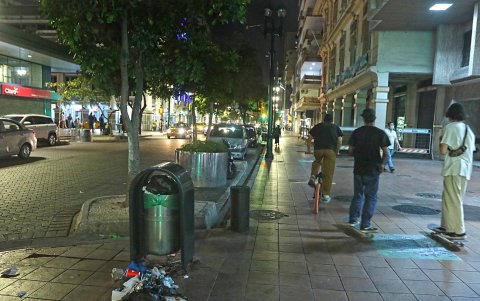 2. En la noche. La luz es escasa en varias zonas y la basura está en cualquier lado, menos en el tacho. Los ciclistas transitan por la vereda, esquivando a los peatones.