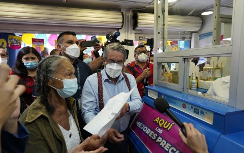 El ministro José Ruales acompaña a la usuaria Bélgica Vera a retirar sus medicinas en una farmacia privada, tras la presentación oficial del programa, el 15 de julio de 2022.