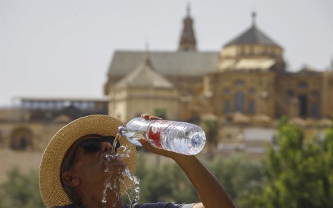 Un turista bebe agua ante la Mezquita-Catedral de Córdoba para combatir la ola de calor este sábado.