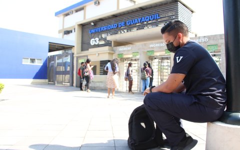 Algunos estudiantes esperan en la parte de afuera de la Universidad de Guayaquil