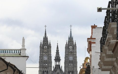 Personas caminan hoy por el centro histórico, cerca a la Basílica del Voto Nacional, en Quito (Ecuador).