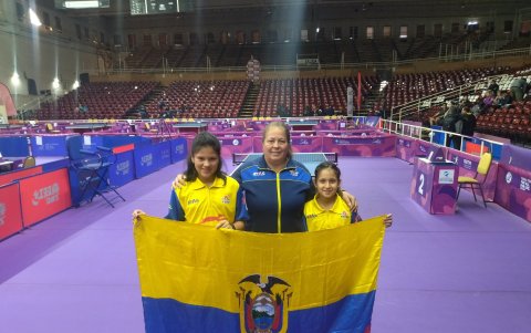 Emily Macay (d), y Alejandra Abril (i) sostienen la bandera de Ecuador tras lograr el título sudamericano en dobles, en Salta.