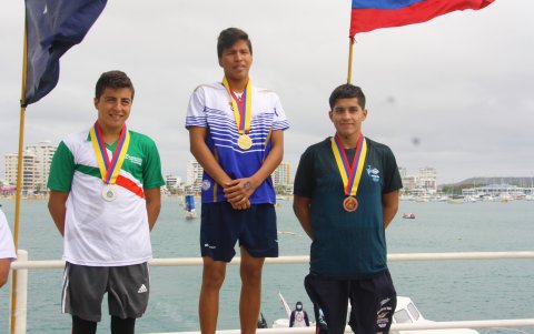El nadador albiceleste (c) luce su medalla de oro luego de ganar uno de sus títulos en el balneario de Salinas.
