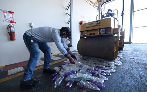 Desarrollo. Una aplanadora pasa por encima de las botellas.