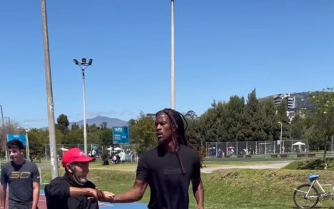 Jimmy Butler choca las manos con un ciudadano mientras juega baloncesto.