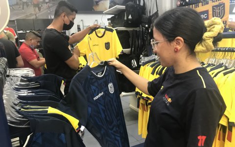 Una aficionada sostiene a camiseta alterna azul de la Tricolor.