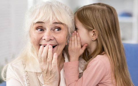 Niña contando secreto a su abuela