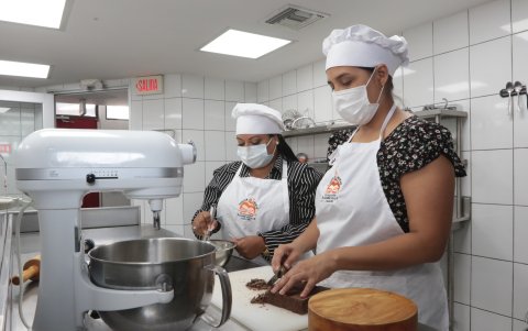 En la cocina. Lissette Oviedo Peñafiel (der.) y Andrea Almeida Saldarriaga se preparan actualmente en los talleres de pastelería y panadería.