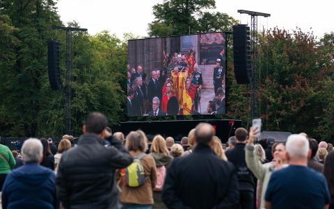 Un grupo de personas ve el funeral de la reina Isabel II en la pantalla en Hyde Park en Londres este lunes.