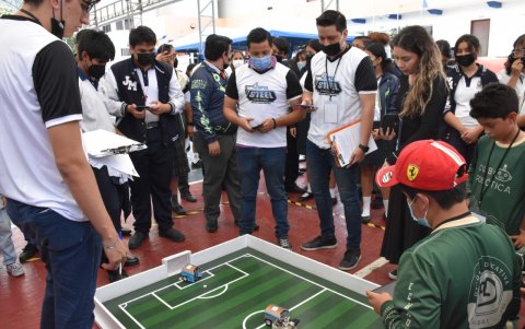 Los estudiantes no despegan sus miradas en los robots durante la competencia.