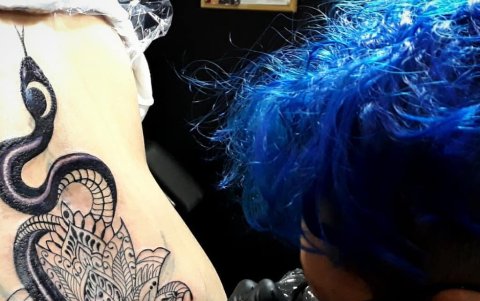 La artista Cindy Parra realizando un diseño de tatuaje.
