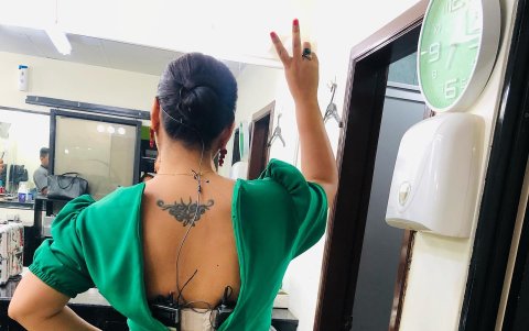 Tiene un tatuaje en la parte alta de la espalda.