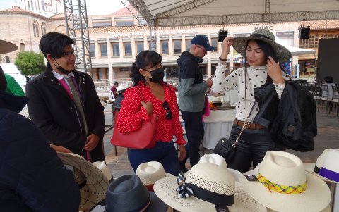 Los turistas compran artesanías en un parque de Cuenca.