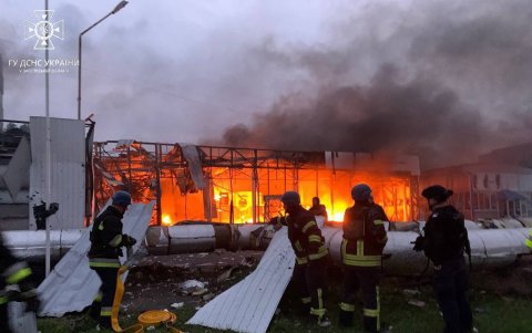 Rescatistas y bomberos trabajan para extinguir un incendio en un sitio atacado con un misil ruso, este martes en la ciudad de Zaporiyia.