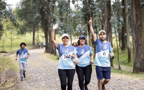 La gran carrera. Un grupo de deportistas saluda mientras transita por uno de los tramos de la Run4Health.