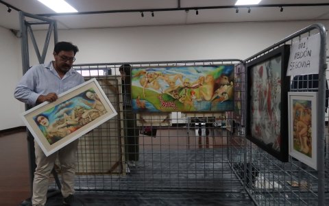 Como en el pasado. Abdón Segovia coloca uno de sus cuadros en uno de los stands colocados en una de las salas del Museo Municipal, tal como sucede en los festivales en el Malecón.