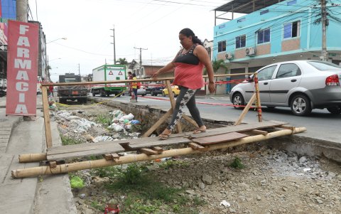 Realidad. Puentes elaborados con madera o montículos de piedra o tierra son usados por residentes o trabajadores de negocios para llegar a la acera de la calle Venezuela, en el sentido de sur a centro.