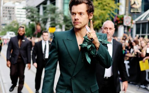 Harry Styles luciendo un conjunto y cartera verda diseñdo por Gucci